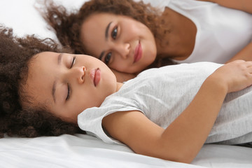 Sticker - African-American mother with sleeping daughter lying on bed