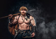 © Fxquadro - Severe barbarian in warrior clothes, posing on a dark background.
