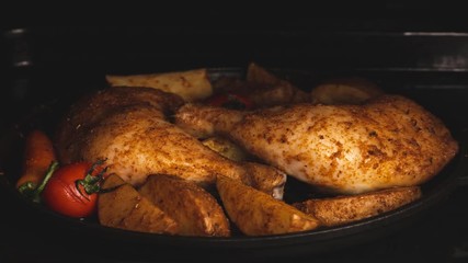 Wall Mural - Roasted chicken legs with potatoes and tomatoes in the oven. Cooking process. Time lapse.