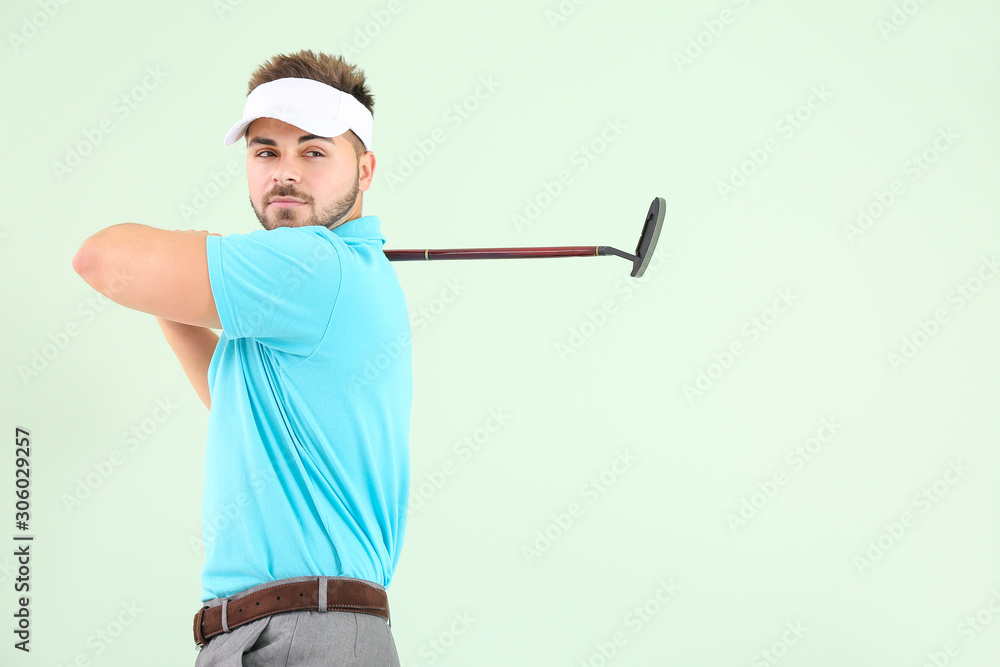 Handsome male golfer on color background