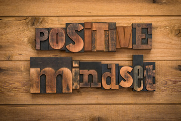 positive mindset, phrase written with vintage letterpress printing blocks on rustic wood background