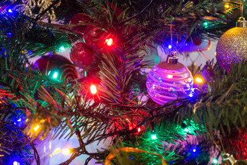 colourful fairy lights and baubles decorate a christmas tree.