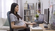 © PRPicturesProduction - Modern mother pregnancy and health care concept. side view of elegant asian japanese pregnant woman working on computer at table in cozy bright home office. maternity lady with big belly at workplace