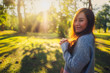 © Farknot Architect - Portrait image of a beautiful asian woman standing among nature in the park before sunset