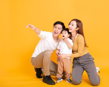 Happy Asian Family Looking Away And Pointing
