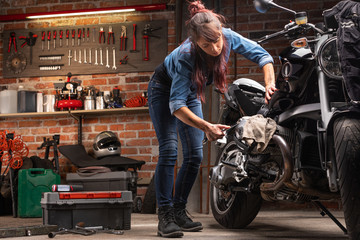 Woman mechanic working on a vintage motorbike