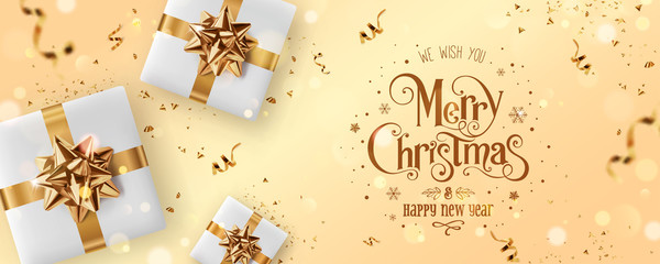 Wall Mural - gold christmas and new year text on gold xmas background with gift boxes, fir branches, gold ribbon,