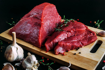 Wall Mural - Fresh and raw meat. Whole piece of red beef ready to cook on the grill or BBQ . Background black blackboard.