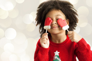 Wall Mural - Happy adorable african american child girl celebrates christmas on light background