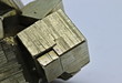 Close up detail on a cube of pyrite isolated single shiny mineral stone, fool's gold, cubic gems, on white limbo background