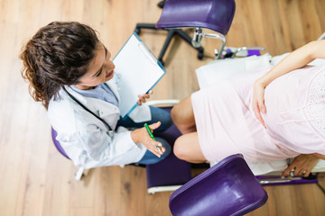 Wall Mural - Beautiful young pregnant woman in gynecological chair during gynecological exam.