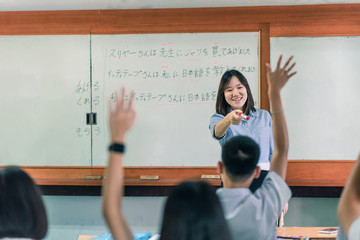 An Asian female teacher is teaching Japanese. The meaning of texts are 