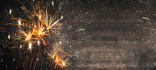 Silvester New Year Party 2025 fireworks background banner panorama long- firework  on rustic dark wooden wood texture, top view with space for text