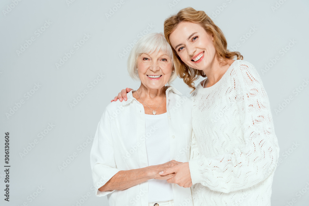 attractive daughter hugging smiling mother and looking at camera isolated on grey - obrazy, fototapety, plakaty 
