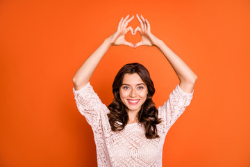 Wall Mural - Portrait of lovely charming girl date with her boyfriend make heart figure finger show passionate love sign wear good looking clothing isolated over orange color background