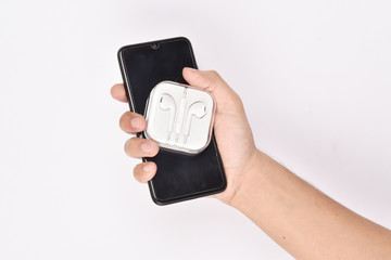 Smartphone with earphone in hand on white background 