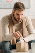 © LIGHTFIELD STUDIOS - diseased man in warm scarf taking napkin from pack