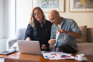 Wall Mural - Customers consulting interior designer online and showing floor plan to screen. Caucasian man and woman in casual showing floor plan to laptop screen. Renovation concept