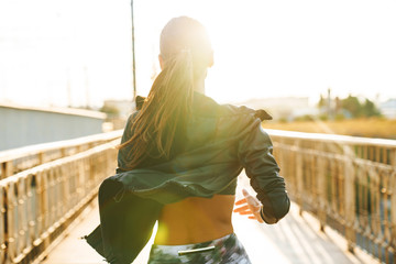 Canvas Print - Strong fitness woman running outdoors by street.