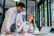 © bnenin - Doctor talking to his young intern in the office. Internship, education and medicine concept.