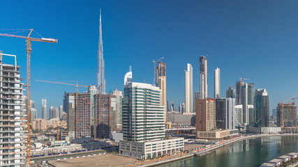 Skyscrapers near canal in Dubai with blue sky aerial timelapse