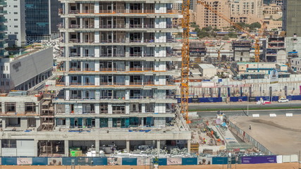 Wall Mural - Aerial view of a skyscrapers under construction with huge cranes timelapse in Dubai.