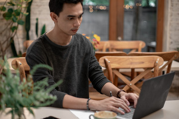 a man is working in his house and drinking coffee and using his mobile talking to his co worker