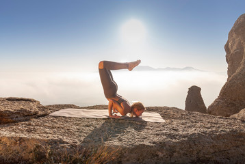 girl practices yoga in the mountains