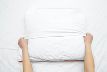Woman Hands On Mattress Surface Changing White Cotton Cover On Pillow. Regular Bed Linen Change. Closeup. Point Of View Shot. Top Down View.