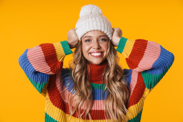 image of cheerful young woman in winter hat and sweater smiling at camera