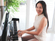 © Phuttharak - Asian young woman playing piano upright in the white room