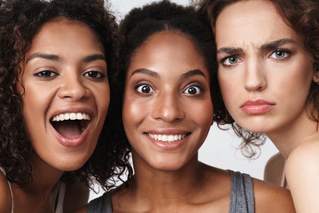 Wall Mural - portrait of brunette multiracial women standing together and looking