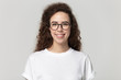 © fizkes - Smiling millennial girl in glasses posing on grey background