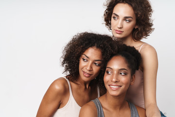 Wall Mural - portrait of three joyful multiracial women smiling and looking aside