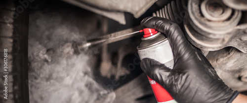 Fotomural Car master mechanic repairer lubricates screws with machine cleaner spray
