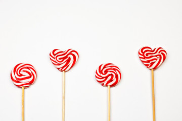 Lollipops. Red and white sweet lollipops on white background. Heart and round shaped spiral lollipops. Sweet emotions concept background. Part of set. 