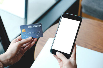 Man's hands holding smartphone with blank screen and credit card,internet banking, online trading, e commerce concept.