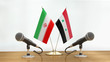 © corund - Microphones and flags pair on a desk over defocused background
