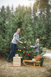 © sofiko14 - Christmas moments, happy mother and little son decorating the Christmas tree with toys, outdoors in winter forest