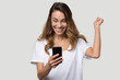 © fizkes - Happy excited woman celebrating success, looking at phone screen