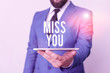 © Artur - Conceptual hand writing showing Miss You. Concept meaning Feeling sad because you are not here anymore loving message Businessman in blue suite with a tie holds lap top in hands