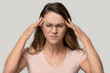 © fizkes - Unhappy woman wearing glasses touching temples, relieving headache