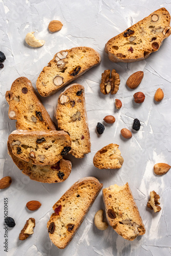 Fotografía Tasty traditional Italian homemade biscotti or cantuccini cookies with hazelnuts, almonds, raisins and walnuts on a light gray background