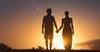 © kieferpix - Man and woman walking together holding hands at sunset. People love and relationships.