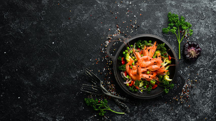 Fried shrimp with vegetables in a frying pan. Seafood. Top view. Free space for your text.