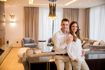 Couple embracing standing in living room of a contemporary apartment