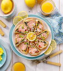 Wall Mural - Salmon in puff pastry, Salmon, spinach and dried tomatoes wrapped in puff pastry in portions, drizzled with with lemon juice on a plate, top view. Stuffed french pastry, delicious appetizer 