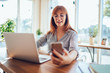 © BullRun - Happy hipster blogger in classic glasses feeling good from fast installation mobile application for sharing media files, Caucasian red hair woman checking notification for cellphone gadget