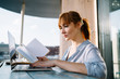 © BullRun - Side view of smart woman spending time for doing college homework in online regime researching information on university website for students, concept of e learning and knowledge education