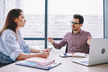Wall Mural - serious female and male colleagues discussing ideas for business startup sitting at desktop together